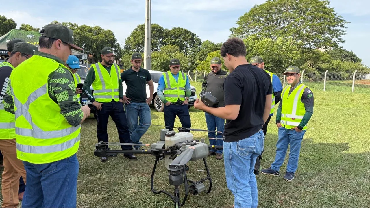 Treinamento prático com grupo de alunos e drone agrícola ao ar livre