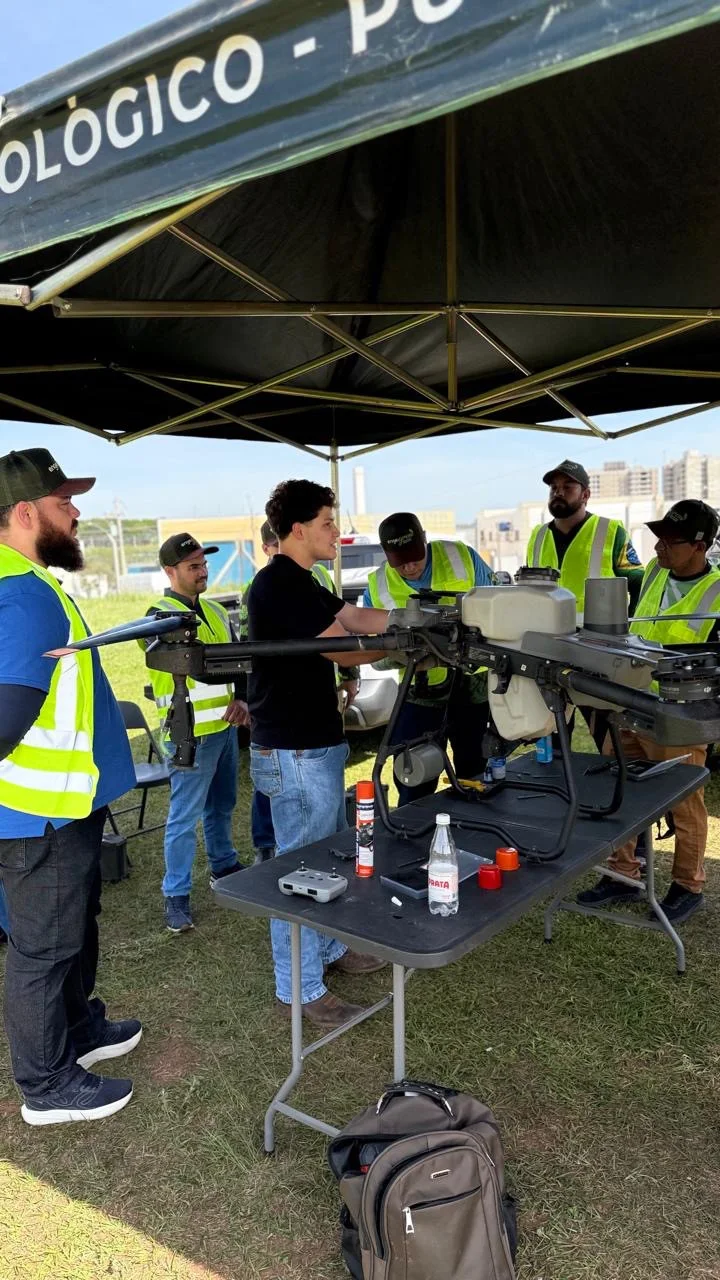 Demonstração técnica com drone agrícola sobre mesa durante treinamento